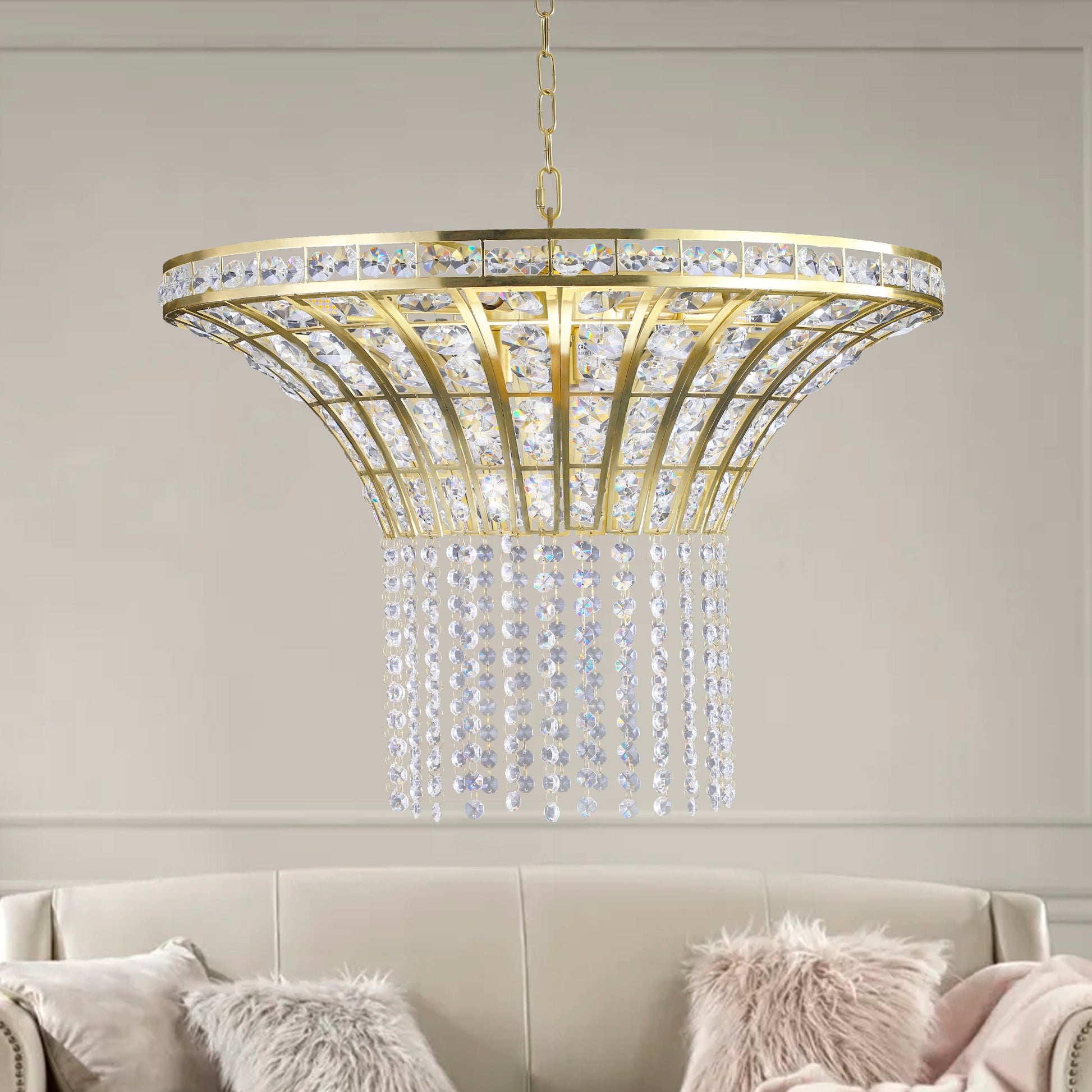 24' round modern crystal chandelier with gold finish, elegant pendant light hanging above a plush couch in a stylish room.